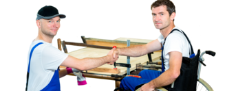 Zwei Arbeiter, einer sitzt im Rollstuhl