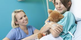 Mädchen in Krankenhausbett mit Krankenschwester